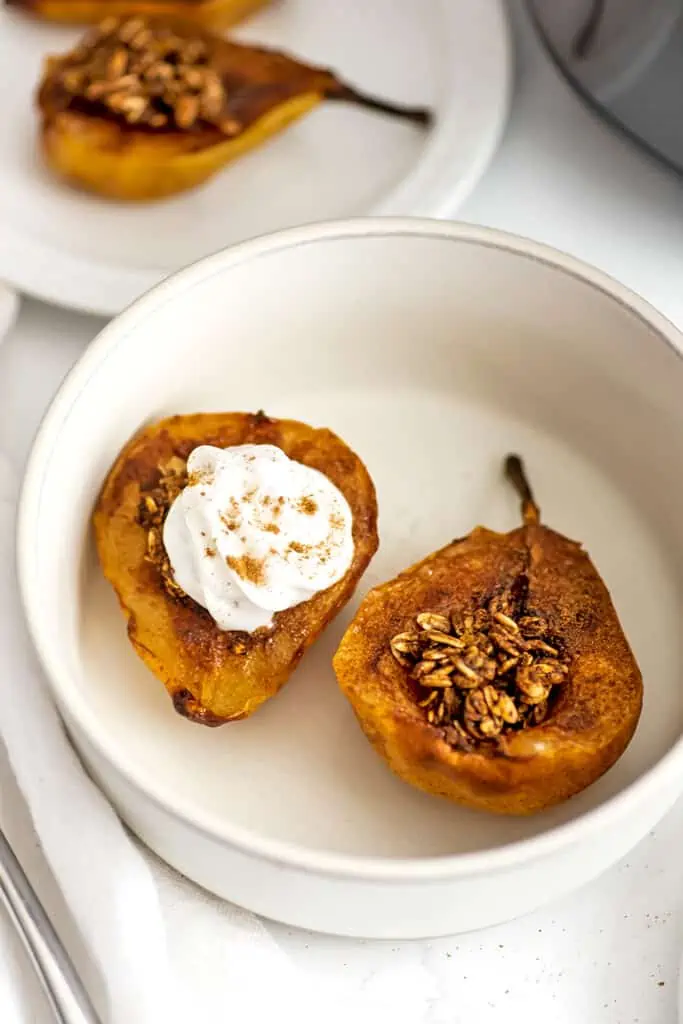 Air fried pear with oat crumble, one has whipped cream on top.