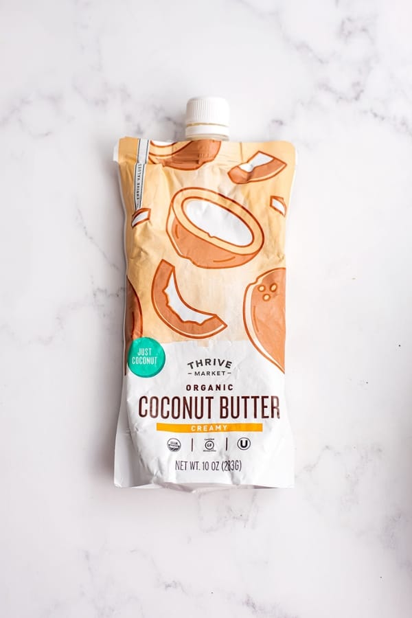 Pouch of coconut butter on marble countertop.