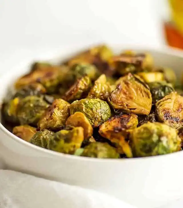 Roasted maple mustard brussel sprouts in a white bowl.