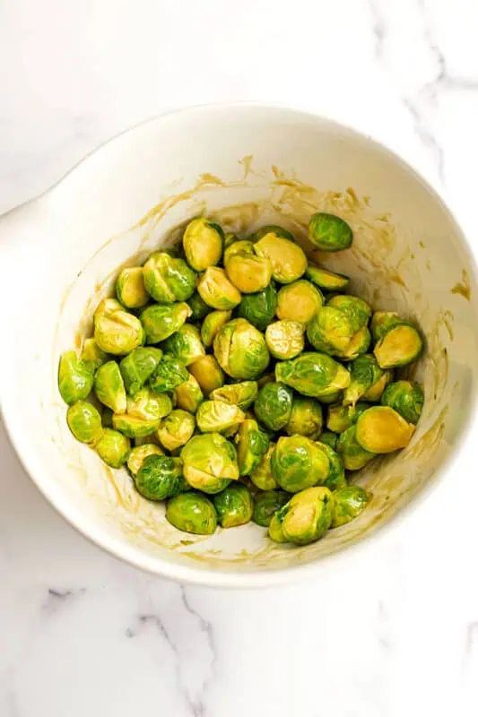 Halved brussel sprouts added to mixing bowl.