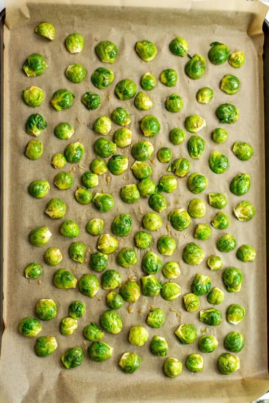 Brussel sprouts on parchment paper lined baking sheet, cut side down.