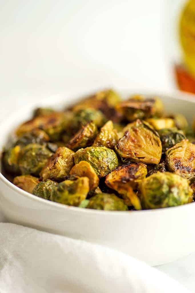 Roasted maple mustard brussel sprouts in a white bowl.