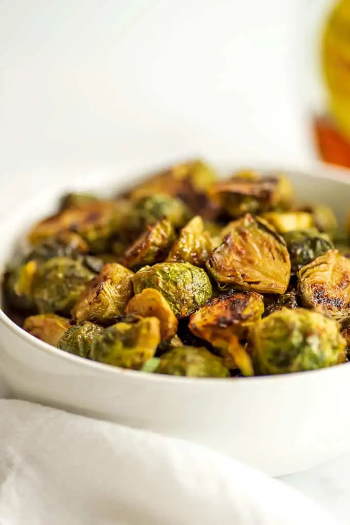 Roasted maple mustard brussel sprouts in a white bowl.