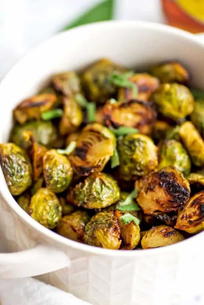 White bowl filled with maple mustard brussel sprouts.