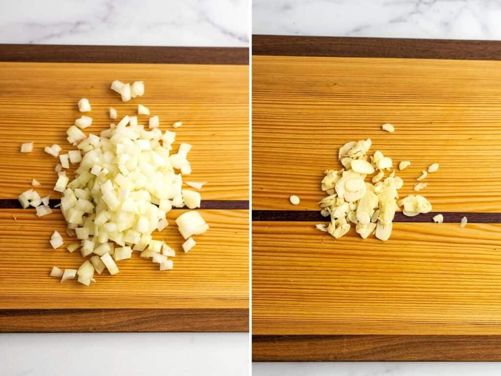 Chopped onion and sliced garlic on a wooden cutting board.