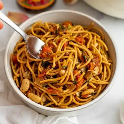 Fork in a bowl filled with tuscan white bean spaghetti.