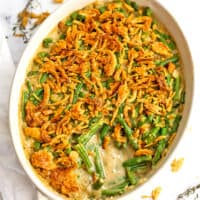 Dairy free green bean casserole in a white casserole dish with a spoonful removed.