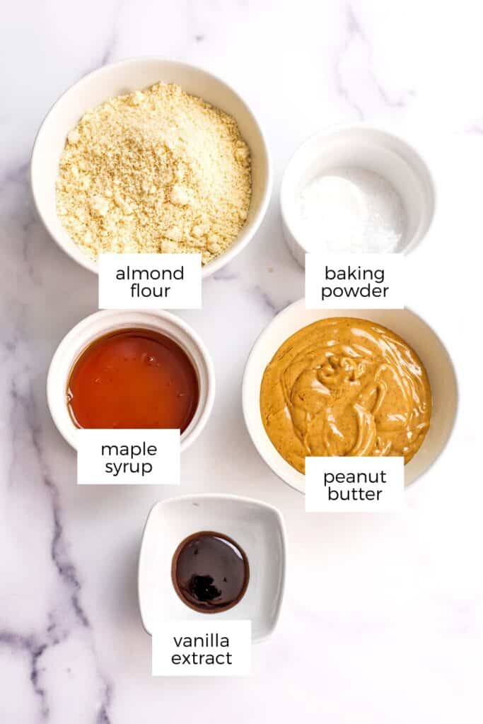 Ingredients to make peanut butter almond flour cookies in white bowls.