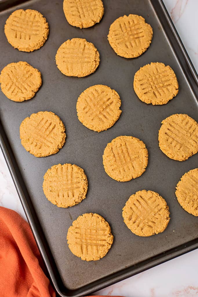 Baking sheet filled with peanut butter almond flour cookies.