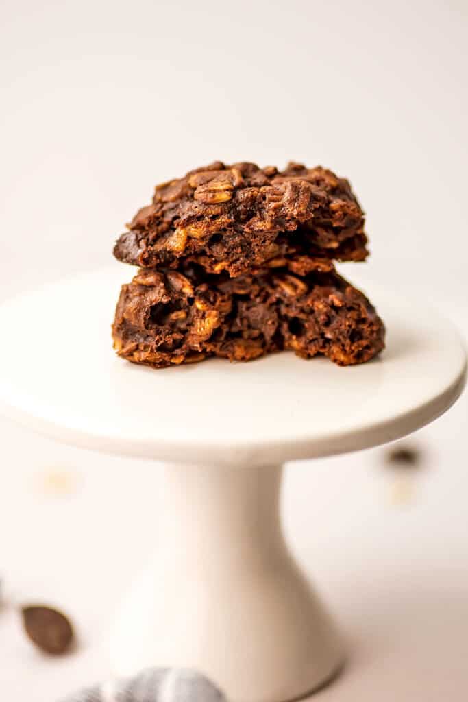 Chocolate oatmeal cookies vegan cut in half on a cake pedestal.