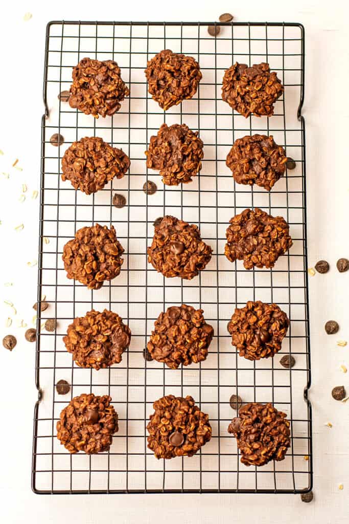 Chocolate oatmeal cookies on a black cooling rack.