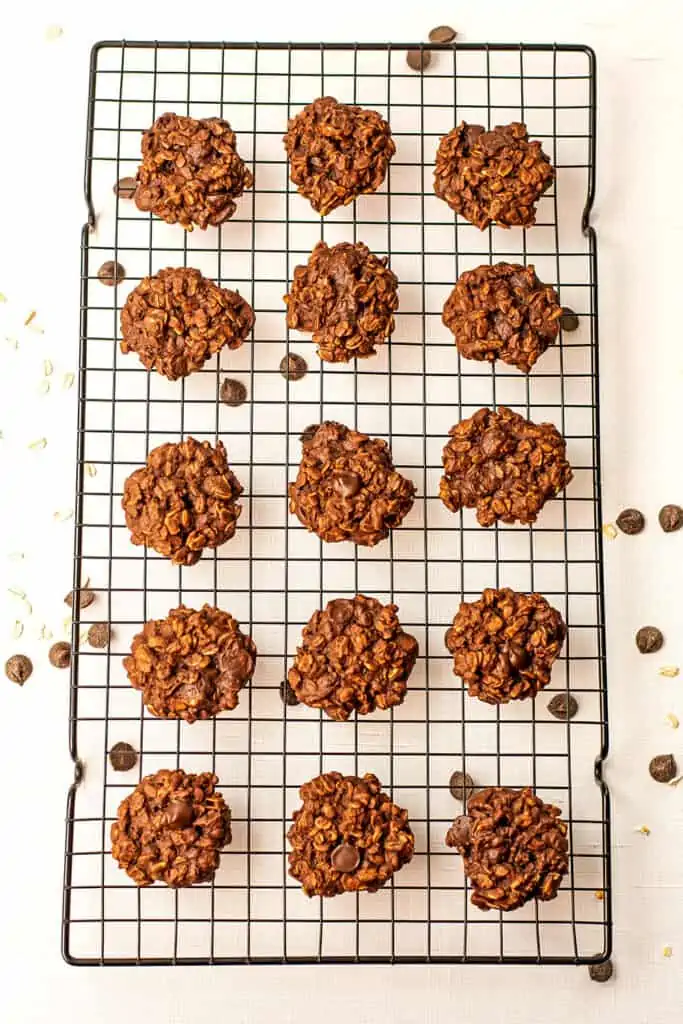 Chocolate oatmeal cookies on a black cooling rack.