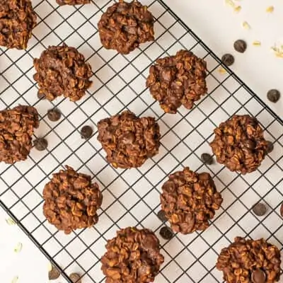 Vegan chocolate oatmeal cookies on a black cooling rack.
