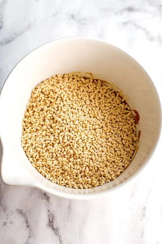 Brown rice krispies added to a bowl with peanut butter mixture