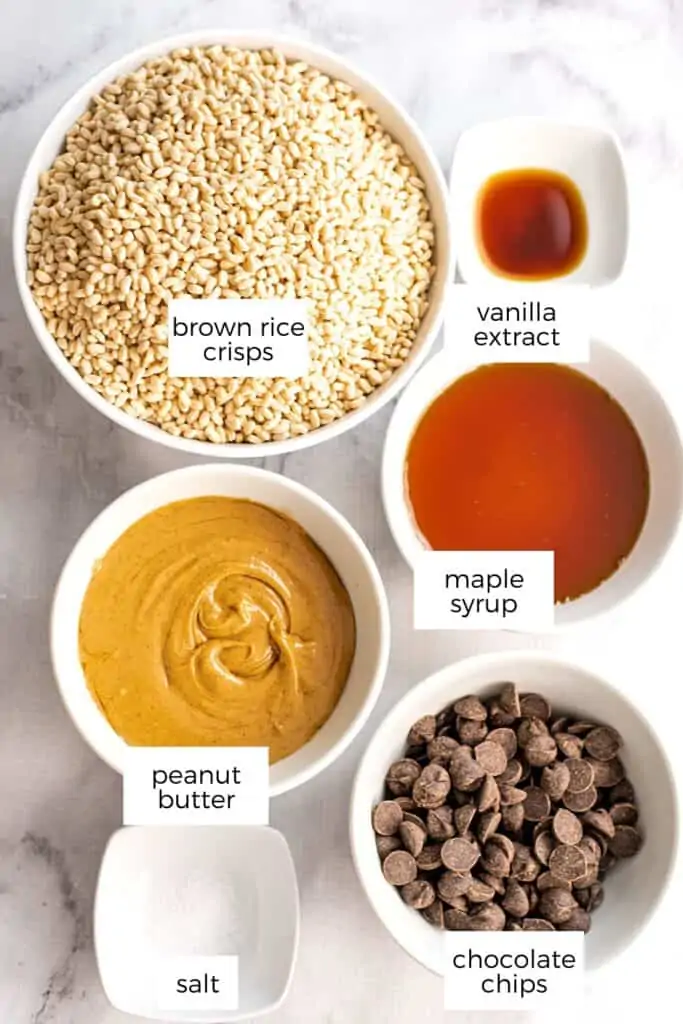 Ingredients to make chocolate peanut butter rice crispy treats in white bowls.