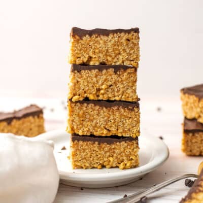 Peanut butter rice krispy treats with chocolate on a white plate.