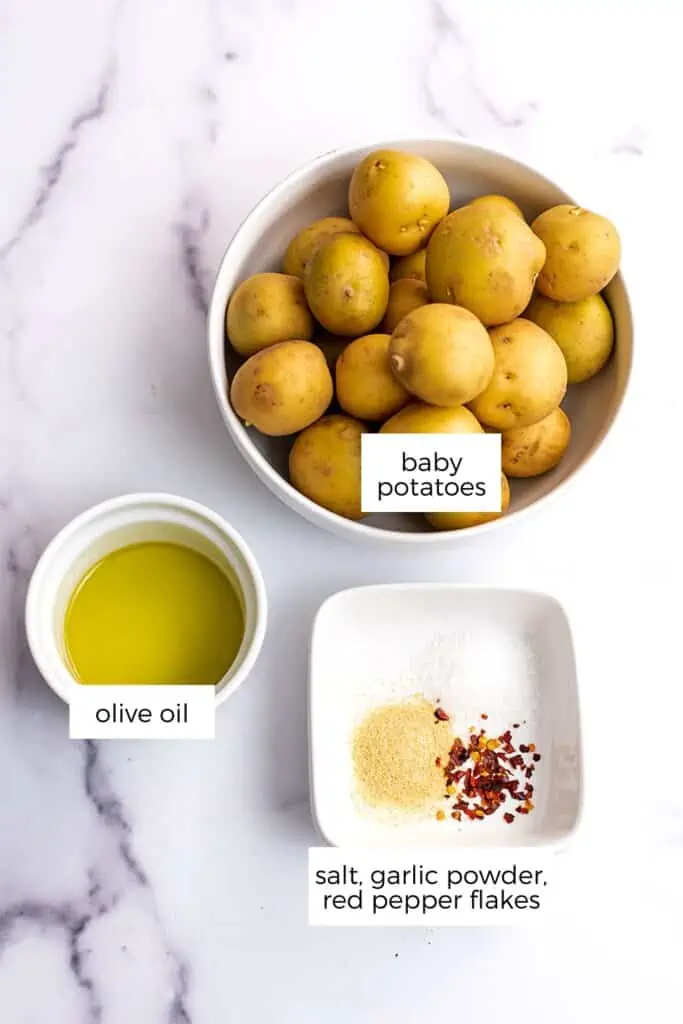 Ingredients to make air fryer smashed potatoes in white bowls.