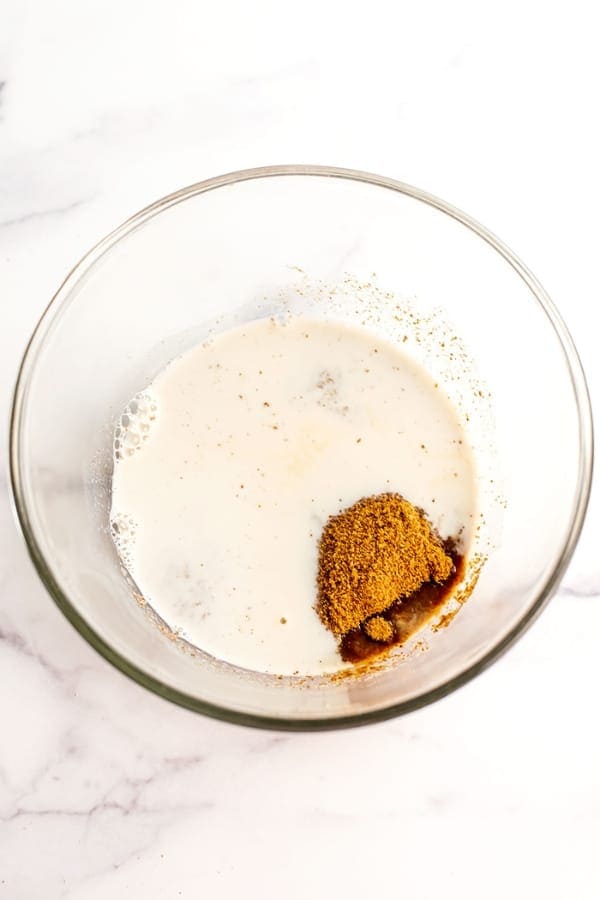 Coconut sugar added to glass bowl with dairy free milk.