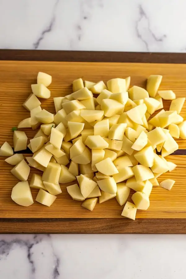 Diced potatoes on a wood cutting board.