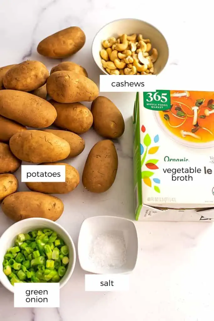 Ingredients to make vegan potato soup on a marble countertop.