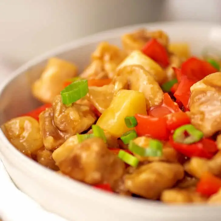 Air fryer sweet and sour chicken in a large white bowl.