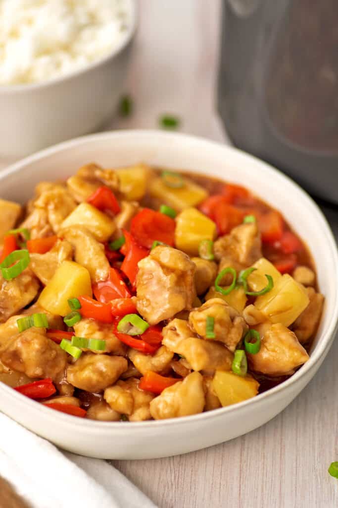 Large white bowl filled with sweet and sour chicken.