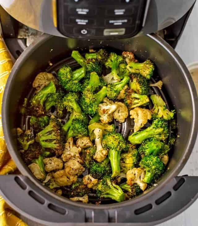 Air fryer broccoli and cauliflower in air fryer basket after baking.