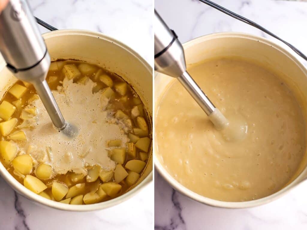Immersion blender blending the potato soup in large white pot.