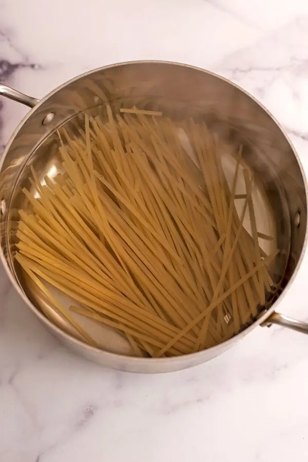 Rice noodles in a pot of boiling water.