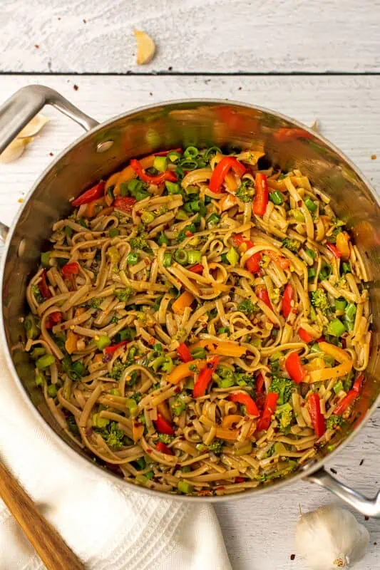 Garlic chili oil noodles with broccoli and bell peppers in a large pot.