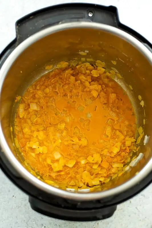 Instant pot filled with cooked onions, turmerkic and water.