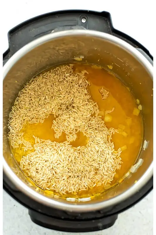 Rice added to the instant pot with turmeric water.