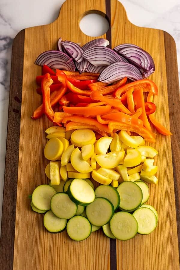 Sliced vegetables on a wood cutting b oard.