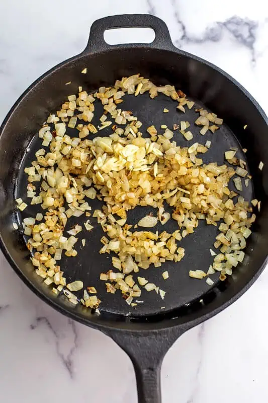 Chopped onions and garlic in a cast iron skillet after cooking.