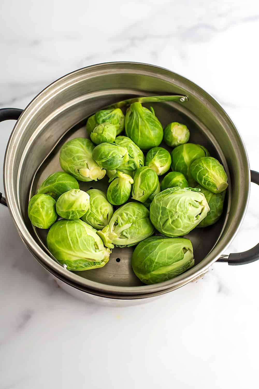 Brussel sprouts in steamer basket before steaming.