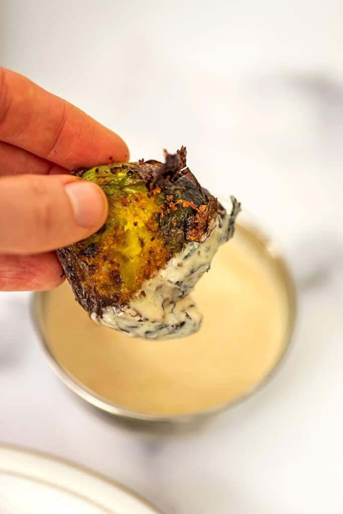 Smashed brussel sprout dipped in lemon tahini sauce.