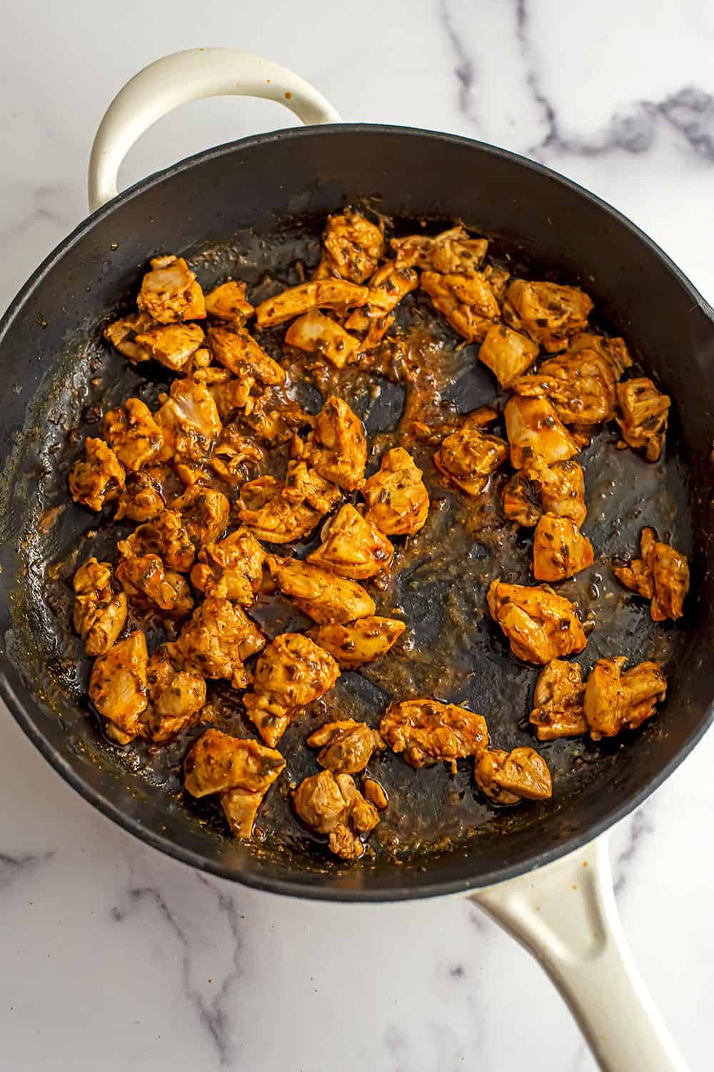 Buffalo chicken bites in large cast iron skillet.