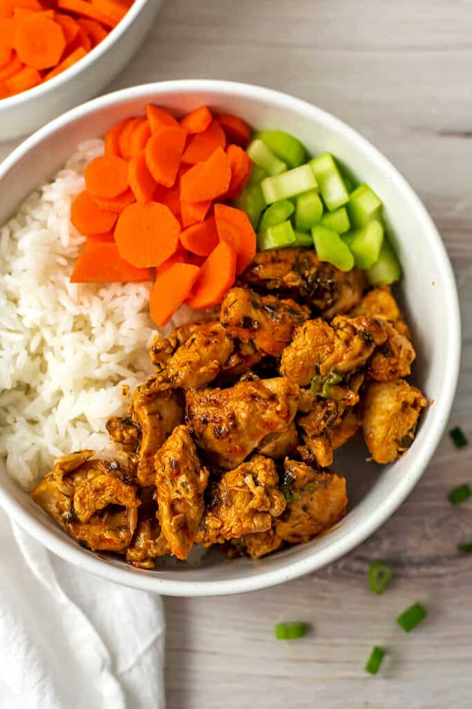 Buffalo chicken bites in bowl with carrots, celery and rice.