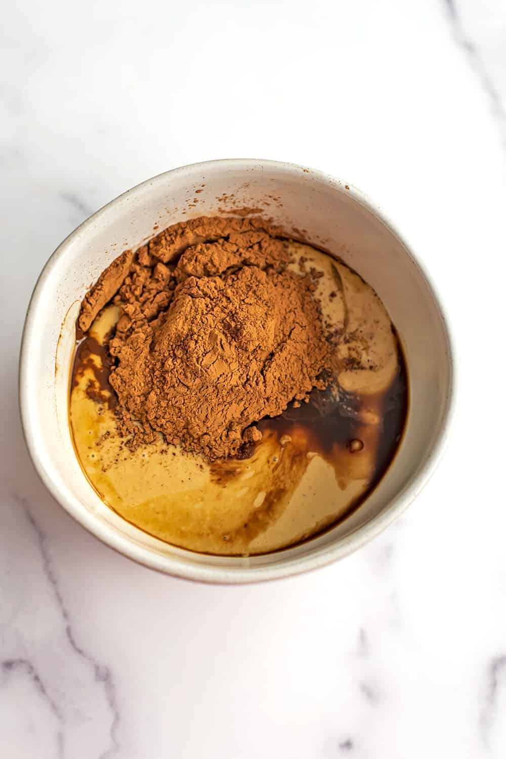 Tahini, maple syrup and cacao powder in a bowl.