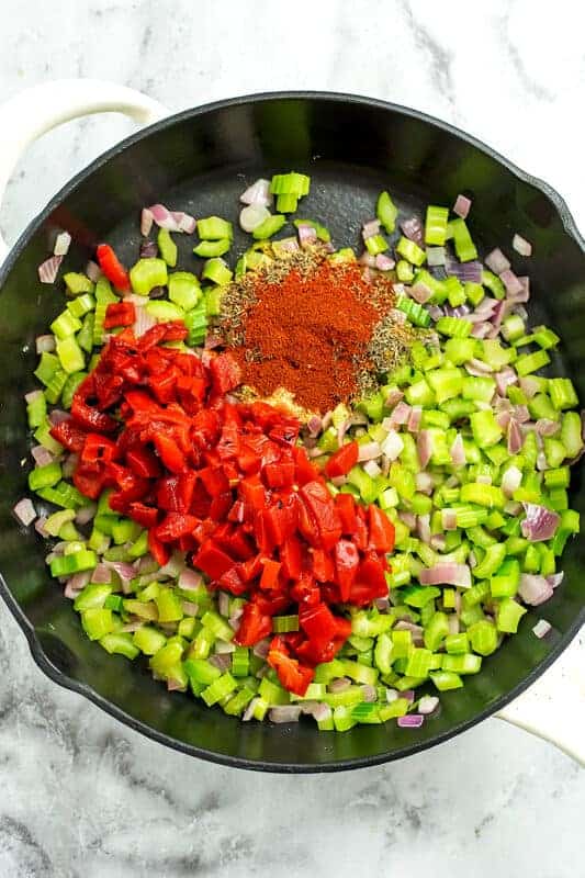 Chopped roasted red peppers and spices added to skillet with celery mixture. 