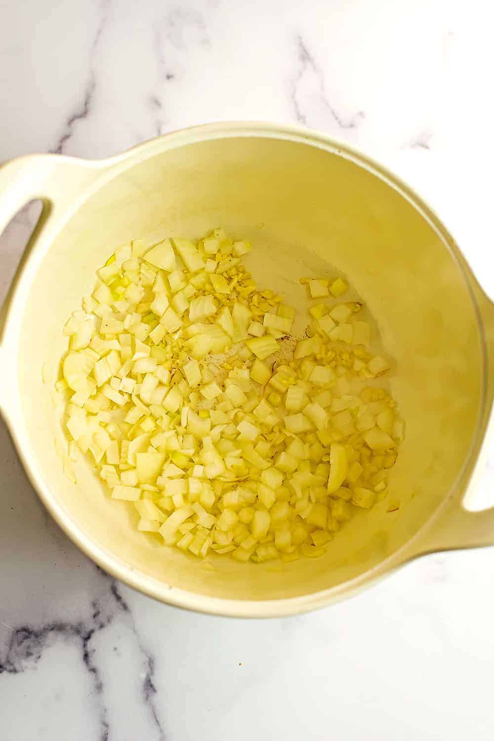 Chopped onion in a large white pot.