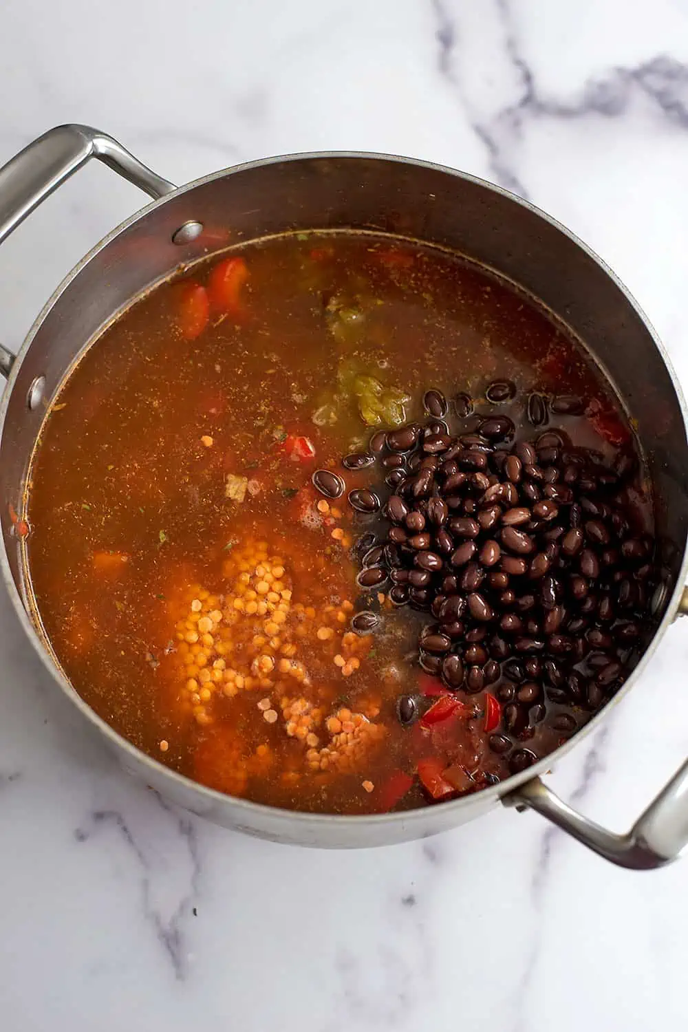 Black beans, lentils and vegetable broth added to pot.