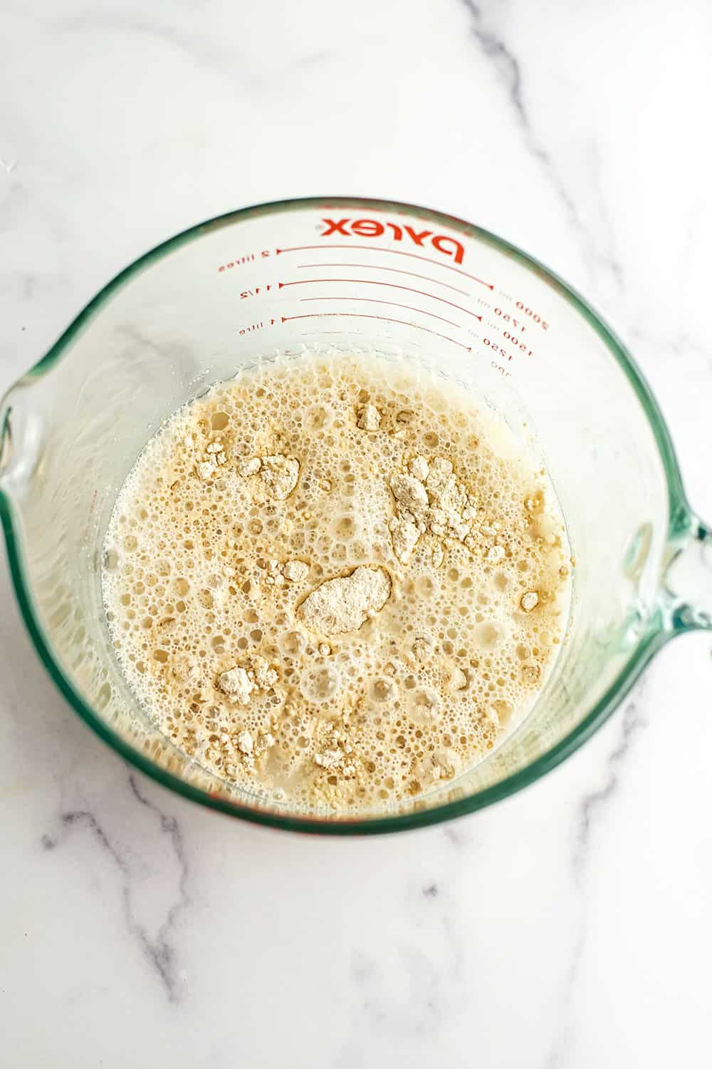 Oat flour, water and salt in a glass mixing bowl.