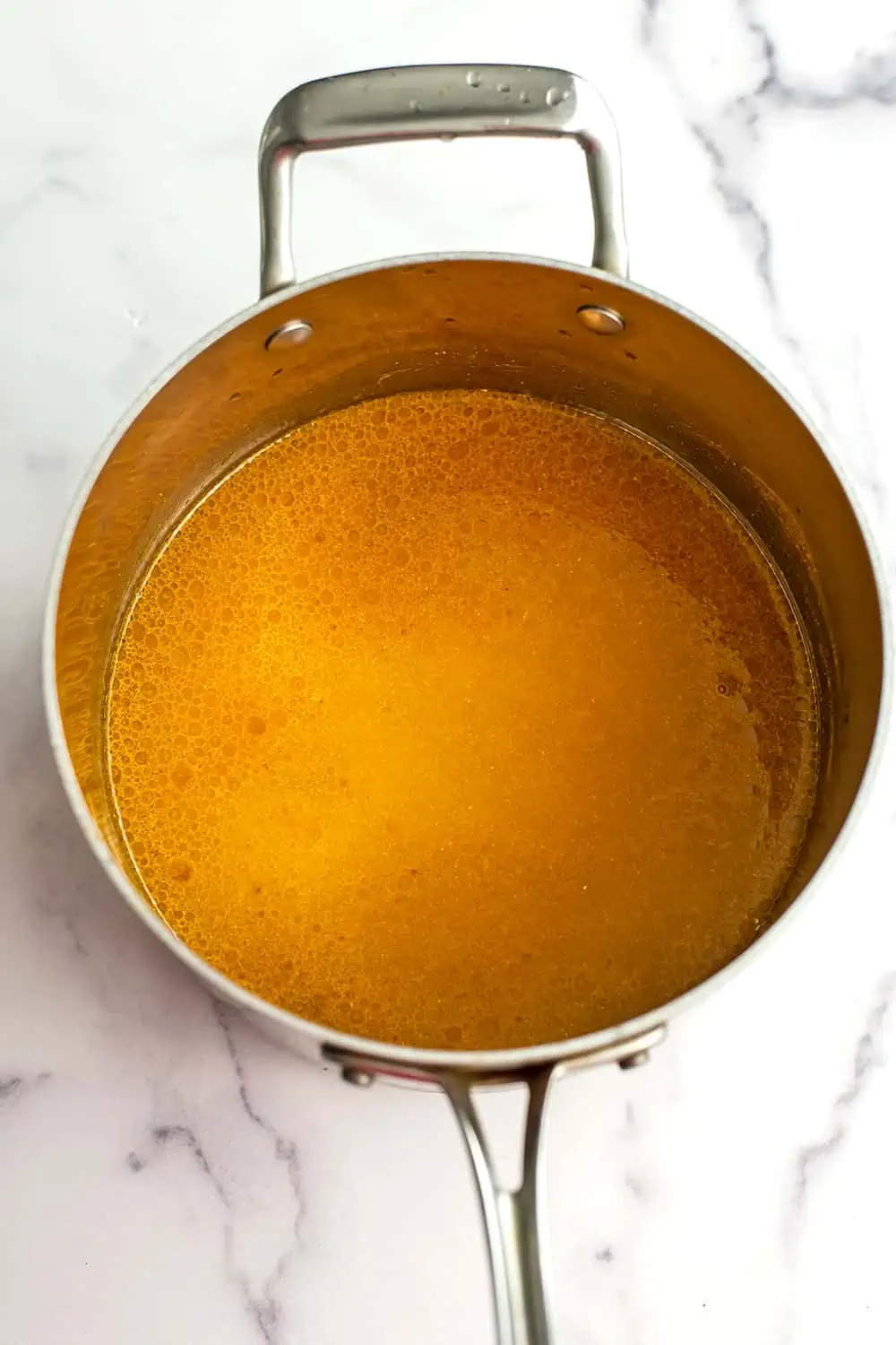 Turmeric and garlic powder dissolved in water in pot.