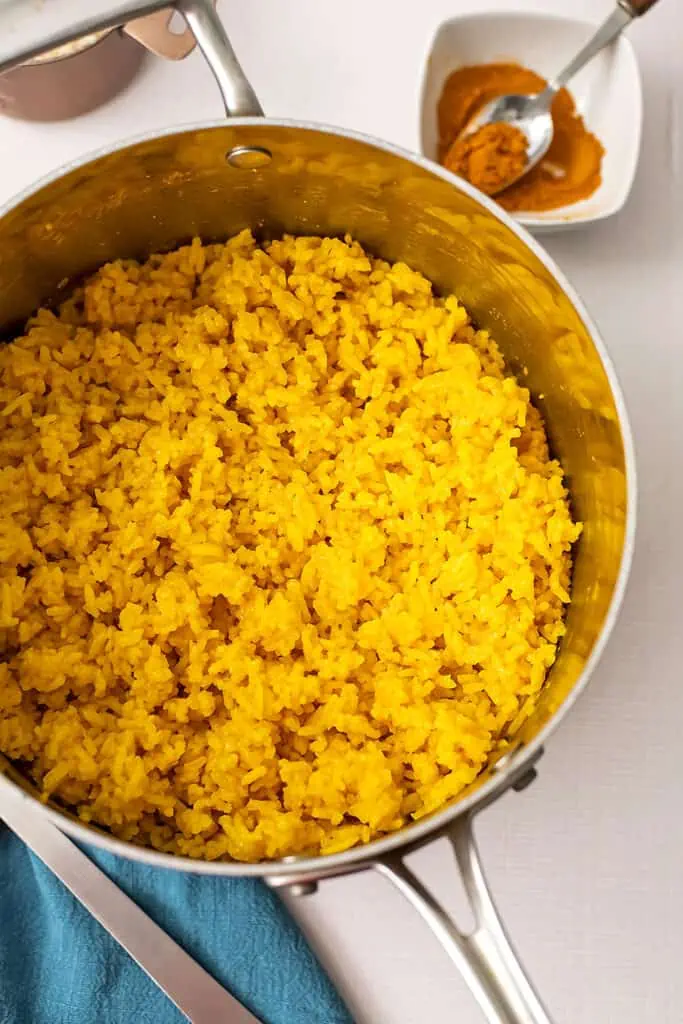 Turmeric garlic rice with small bowl of turmeric in the background.