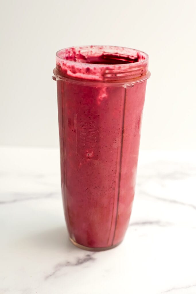 All ingredients for a Blackberry Raspberry Smoothie in a blender cup after being blended.