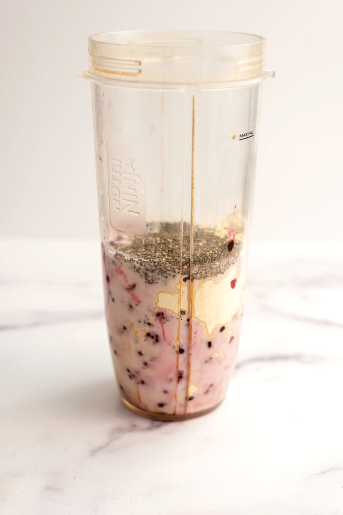 All ingredients for a Blackberry Raspberry Smoothie in a blender cup before being blended.