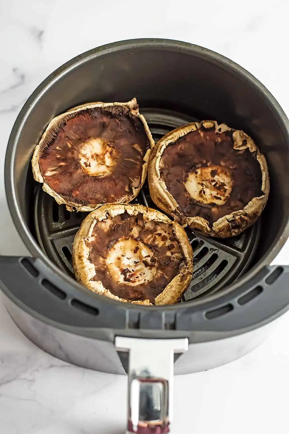 Portobello mushrooms in the air fryer before cooking.