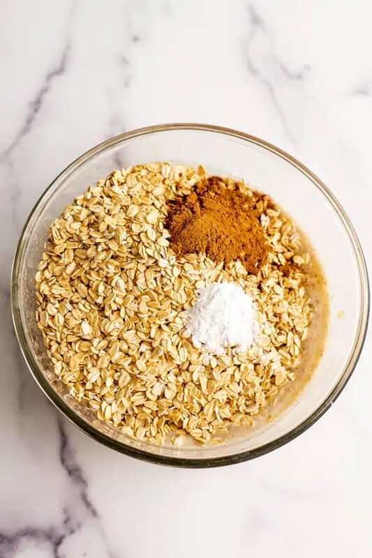 Rolled oats, cinnamon and baking powder in a glass bowl.