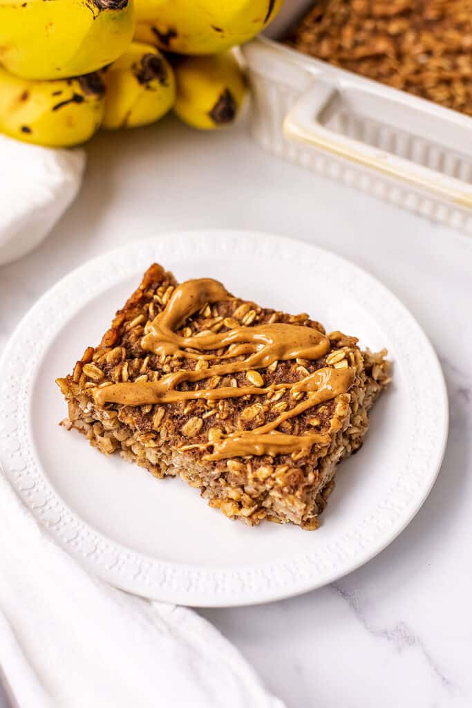 Peanut butter drizzled over a slice of banana bread baked oats.